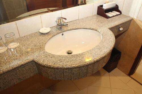 a bathroom counter with a sink in a hotel room at Swiss-Belhotel Borneo Samarinda in Samarinda