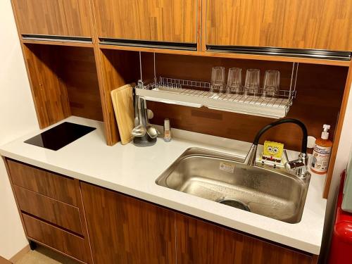 a kitchen with a stainless steel sink and wooden cabinets at 18 Hongik Univ Best location city view in Seoul