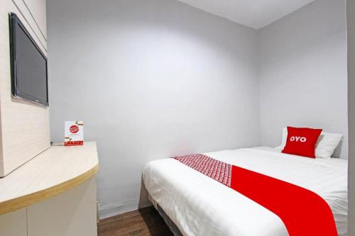 a bedroom with a bed with a red and white blanket at OYO 91531 Dreamstay 2 in Semarang