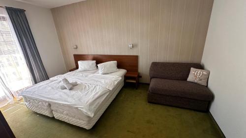 a hotel room with a bed and a chair at Apartmány Timea B 201 in Veľká Lomnica