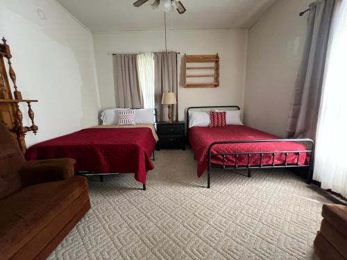 a bedroom with two beds with red covers and a couch at Mixon Villa-Laurel in Laurel