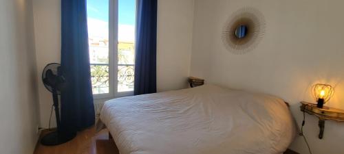 une petite chambre avec un lit et une fenêtre dans l'établissement Spacious apartment, center, close to beach and train station, à Saint-Raphaël