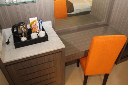 a room with a desk with a coffee maker and a chair at Swiss-Belhotel Borneo Samarinda in Samarinda