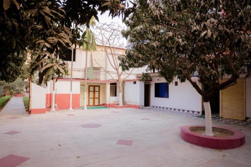 a building with a tree in the middle of a courtyard at Garden View Villa in Rājshāhi