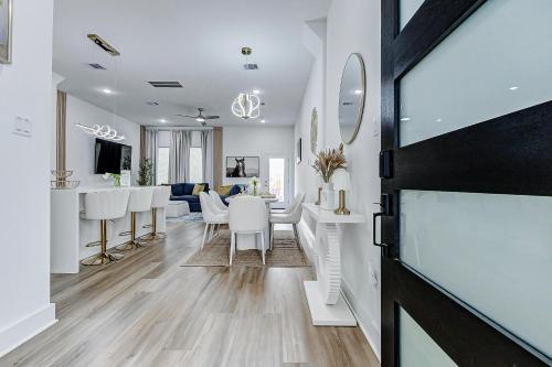 a dining room and living room with white chairs and a table at Premier Luxe Houston Getaway NRG Med Center in Houston