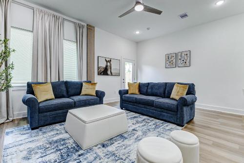 a living room with two blue couches and a table at Premier Luxe Houston Getaway NRG Med Center in Houston