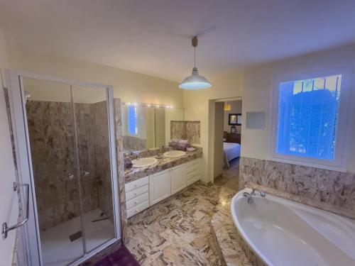 une salle de bain avec une baignoire, une douche et un lavabo dans l'établissement Beauséjour, à La Celle-sous-Gouzon