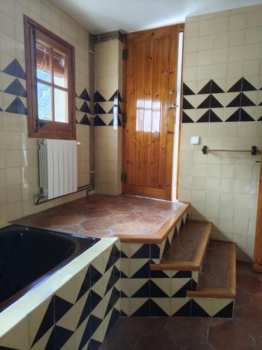 a bathroom with a bath tub and a sink at Casa rural entera en Parque Natural de los Puertos in Alfara de Carles