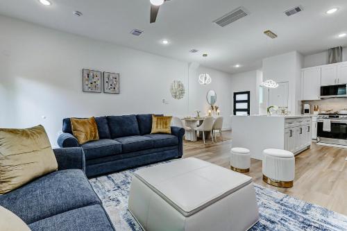 a living room with a blue couch and a kitchen at Premier Luxe Houston Getaway NRG Med Center in Houston