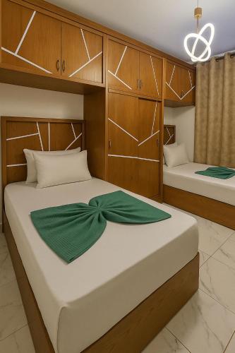 a bedroom with two beds and wooden cabinets at Private Chalet with Relaxing Outdoor Area in Port Said