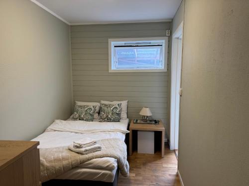 a small bedroom with a bed and a window at Small apartment in Elnesvågen in Svinøya