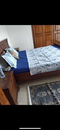 a bedroom with a bed and a wooden cabinet and a rug at Marina in Akouda