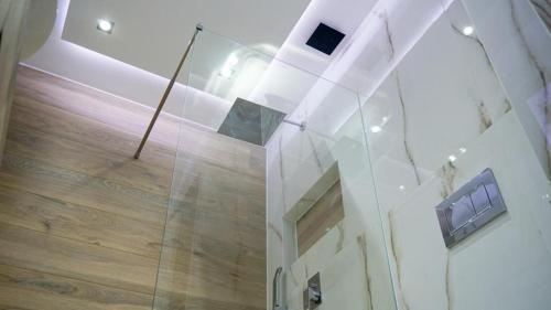 a glass wall in a room with a wooden floor at P & K Design LTD Flats in Nea Moudania