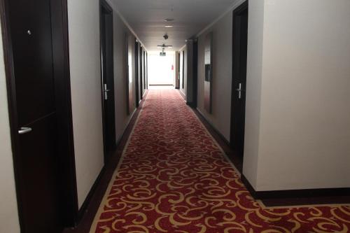 a long hallway with a red carpeted corridor at Swiss-Belhotel Borneo Samarinda in Samarinda