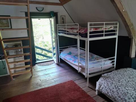 Cette chambre comprend 2 lits superposés et une porte. dans l'établissement cottage, à Condé-sur-Noireau