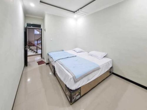 a bedroom with a bed in a white room at Villa putih 10 kamar in Tlekung