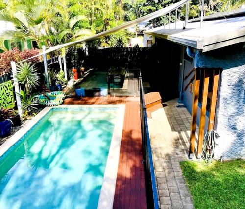 a swimming pool in a yard with a house at Sandy Feet Retreat - 50m from Four Mile Beach in Port Douglas