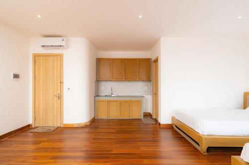 a bedroom with a bed and a kitchen with a sink at Ocean Hill Lodge Phú Quốc in Phu Quoc