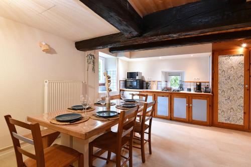 une cuisine et une salle à manger avec une table et des chaises en bois dans l'établissement l'Essentiel Proche Kaysersberg & Lacblanc, à Orbey
