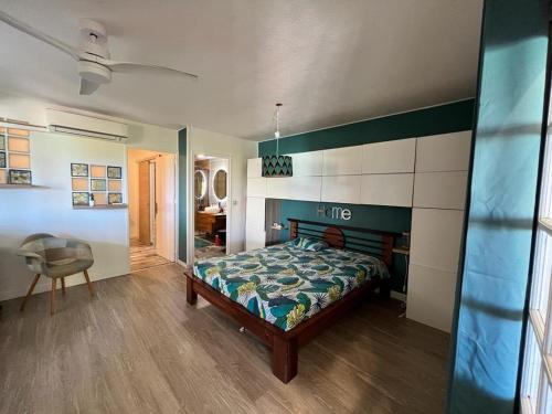 une chambre avec un lit et une chaise dedans dans l'établissement TI PARADI VUE MER, à Saint-François