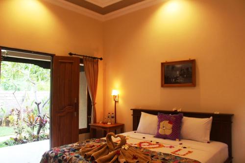 a bedroom with a bed and a window at Pande Guest House in Pemuteran