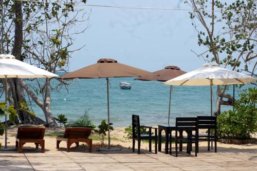 a group of tables and chairs with umbrellas on the beach at Gold Sand Beach Bungalow in Phu Quoc