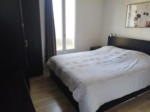 un lit dans une chambre avec une grande fenêtre dans l'établissement Villa central 500m des plages, à Roquebrune-Cap-Martin