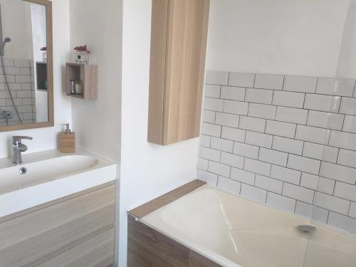 La salle de bains blanche est pourvue d'un lavabo et d'une baignoire. dans l'établissement Villa central 500m des plages, à Roquebrune-Cap-Martin