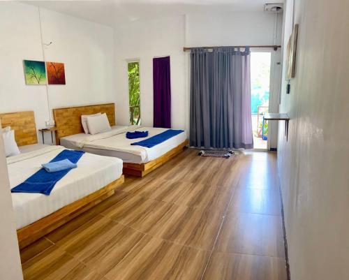 a bedroom with two beds and a wooden floor at Sweet Time Bungalows in Koh Rong Sanloem