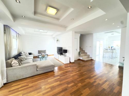 a living room with a couch and a television at Wealthystays Duplex in the Heart of Nicosia in Nicosia