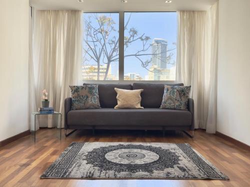 a living room with a couch and a large window at Wealthystays Duplex in the Heart of Nicosia in Nicosia