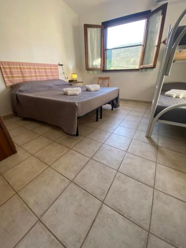 a bedroom with a bed and a tiled floor at Affitta Camere L'Oleandro in Torpè