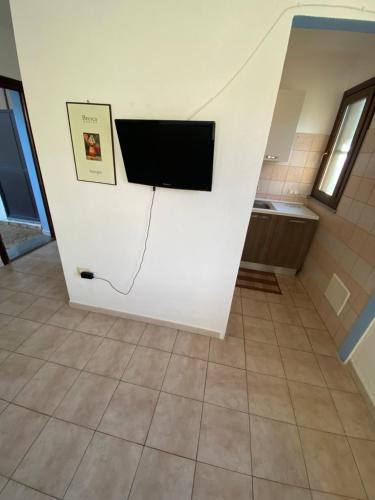 a room with a flat screen tv on a wall at Affitta Camere L'Oleandro in Torpè