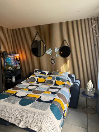 a bedroom with a bed with a colorful comforter at Maison idéalement située à Boulogne sur mer, Gite La Vie Est Belle in Boulogne-sur-Mer