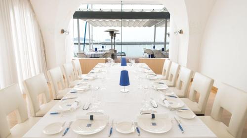 a long table with white plates and silverware on it at Hotel Limani in Setouchi