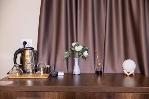 a table with a vase of flowers and a mixer at 4R Colombo Hotel in Tirana