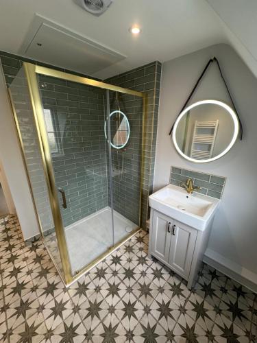 a bathroom with a shower and a sink and a mirror at Black Horse in Brent Pelham