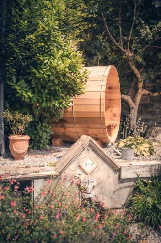 a wooden barrel sitting in a garden with plants at Maison La Grande Ourse in Beaucens