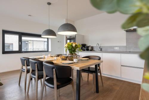a kitchen with a dining room table and chairs at Hello Zeeland - Water villa Veerse Wende with fully fenced terrace in Arnemuiden