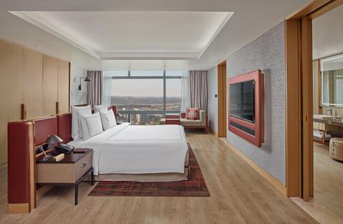 a large bedroom with a large white bed and a desk at Swissôtel Clark Philippines in Clark