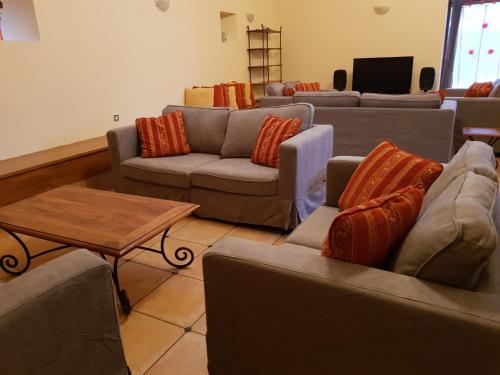 un salon avec des canapés et une table basse dans l'établissement Gite - Le Domaine des Hallais, à Saint-Pierre-sur-Erve