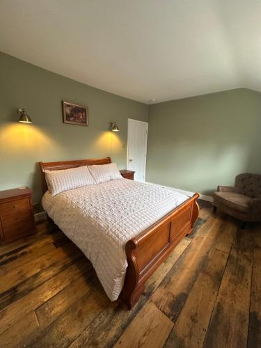 a bedroom with a large bed and a chair at Black Horse in Brent Pelham