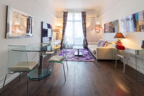 un salon avec une table en verre et un canapé dans l'établissement Champs Elysées Apartment, à Paris