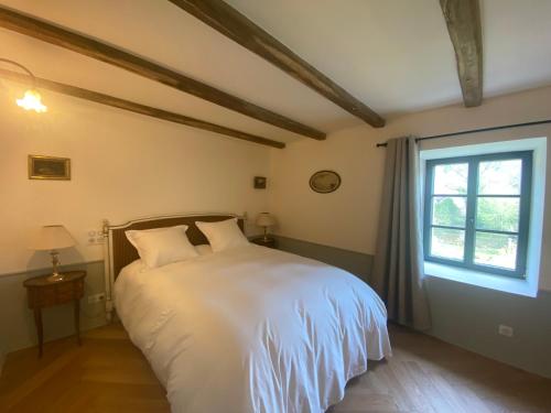 a bedroom with a white bed and a window at Domaine hotel de France in Cunfin