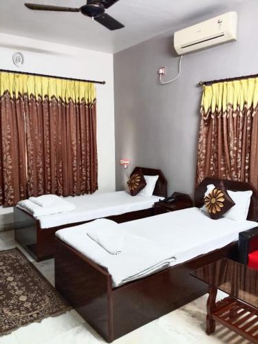 a room with two beds and a window at AKG INN Kolkata in Salt Lake City