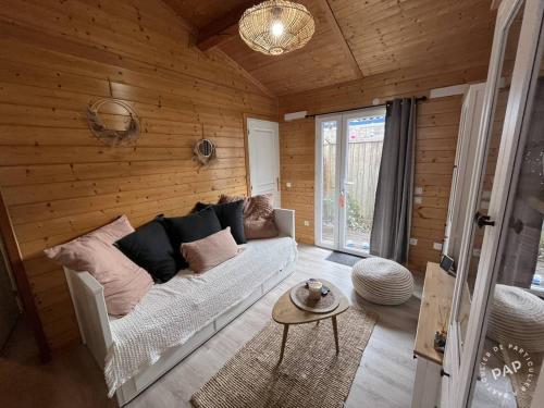 - un salon avec un canapé blanc dans un mur en bois dans l'établissement Chalet 6 Personnes au calme dans les landes-Mimizan, à Bias