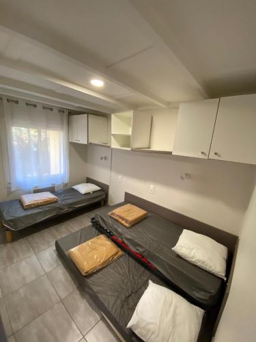 Cette chambre comprend 2 lits superposés et des armoires blanches. dans l'établissement LES COTTAGES DE LEON, à Léon