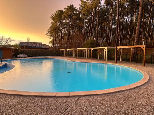 une grande piscine au milieu d'une cour dans l'établissement Chalet 6 Personnes au calme dans les landes-Mimizan, à Bias