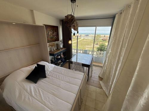une chambre avec un lit, une table et une fenêtre dans l'établissement Appartement 2 pièces Port la Nouvelle PN430-026, à Port-la-Nouvelle