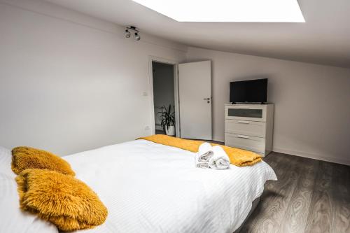 a bedroom with a large white bed and a television at Casa Chirila in Giarmata Vii